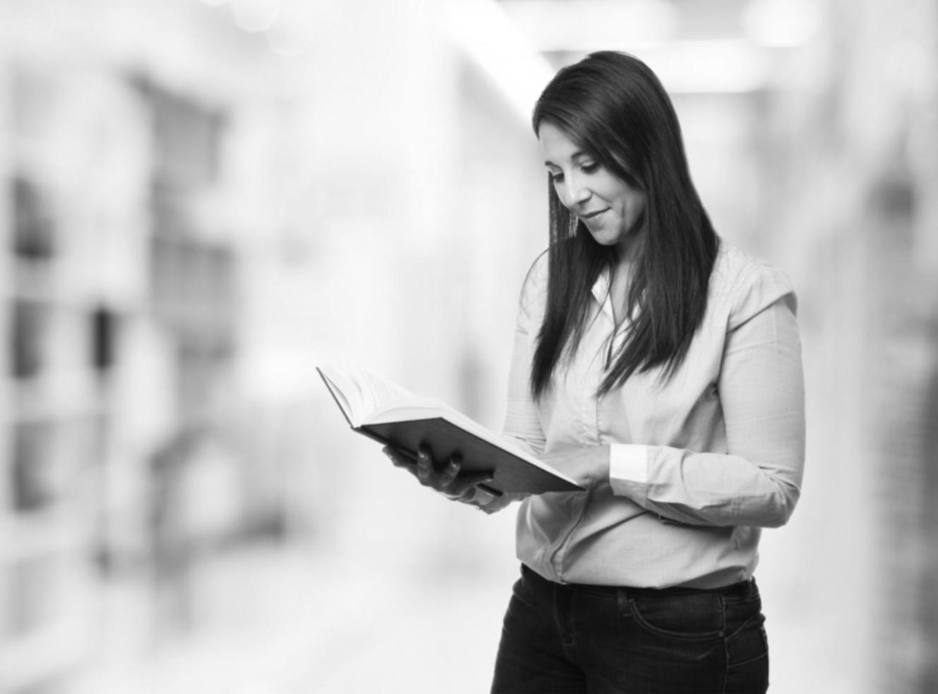 Person reviewing financial reports on tablet with coffee
